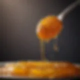 Close-up of golden honey dripping from a spoon