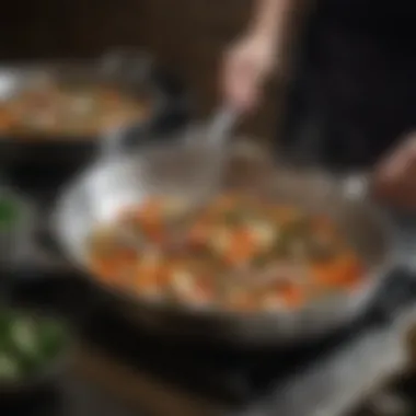 A stainless steel sauté pan with vegetables being sautéed