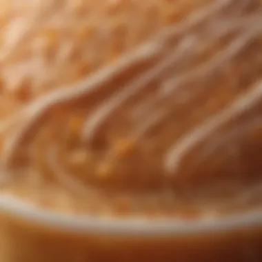 A close-up of a Dunkin' caramel drink emphasizing the intricate details of its foam and caramel drizzle.