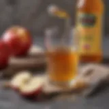 A glass of apple cider vinegar with a measuring spoon beside it