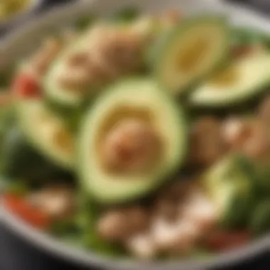 A close-up of sliced avocados and chicken pieces in a salad.